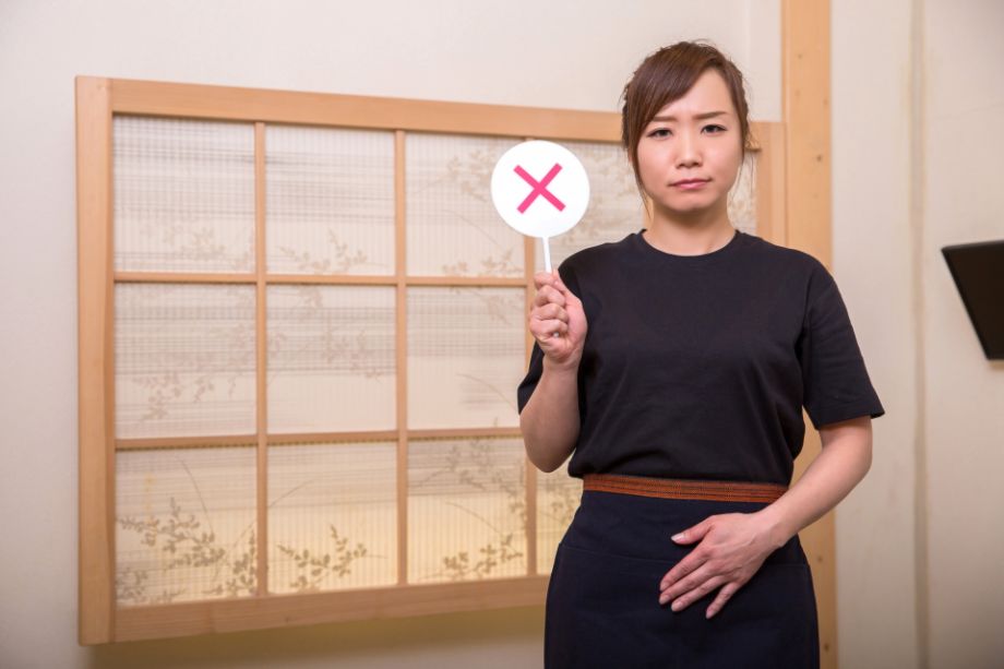 バツマークを持つ女性４