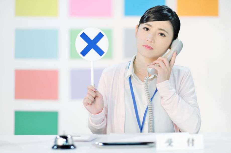 バツマークを持つ女性２